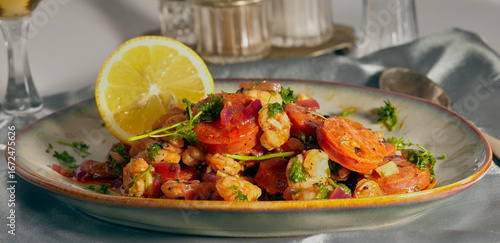 Chorizo and prawns in a sauce with herbs sprinkled on top.