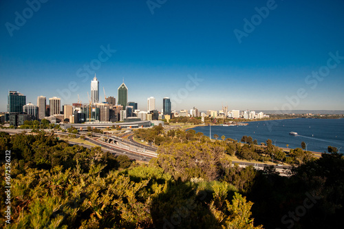 Modern skyline of Perth, Western Australia, with skyscrapers and green park under a clear blue sky.