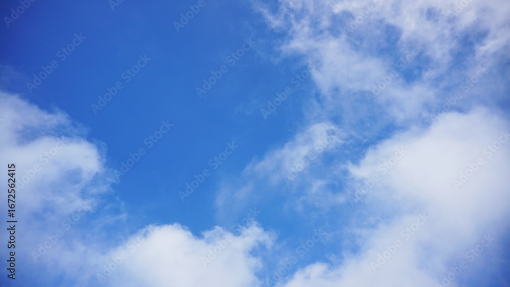 Obraz premium Clear blue sky and fluffy clouds in a peaceful atmosphere