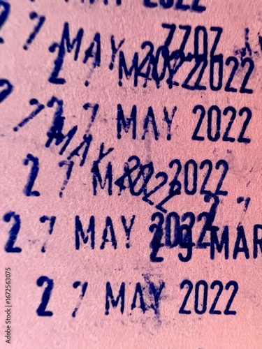 Dater Stamp blue marks with dates and years from stamped on pink paper background.