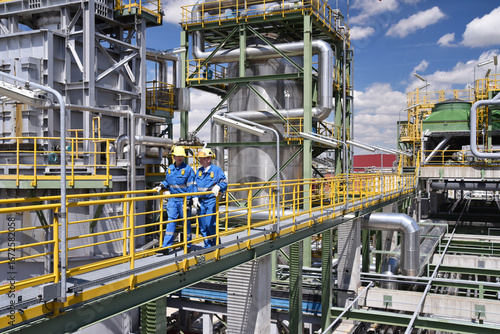 group of workers professional equipment in a petroleum refinery - modern buildings and industrial facilities for the production of fuel and gas