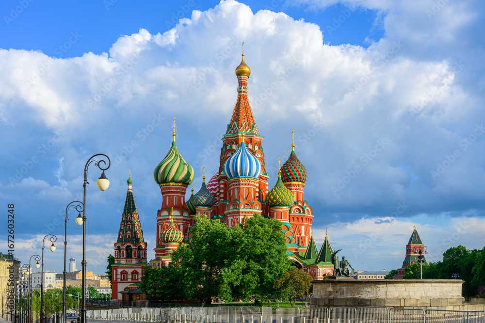 Fototapeta premium Colorful Saint Basil’s Cathedral with onion domes on Red Square in Moscow, Russia, landmark Orthodox church and famous tourist attraction against blue sky and clouds in summer
