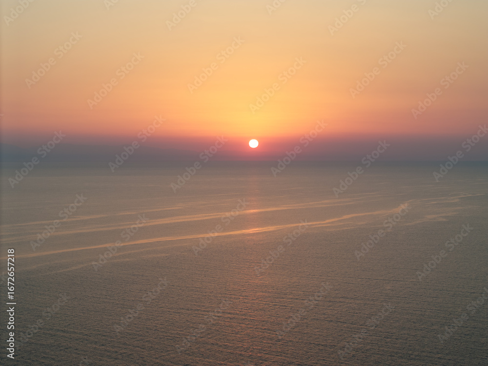 Φωτογραφία The sun sets over the Aegean sea in Kassandra, Greece, painting the sky with war