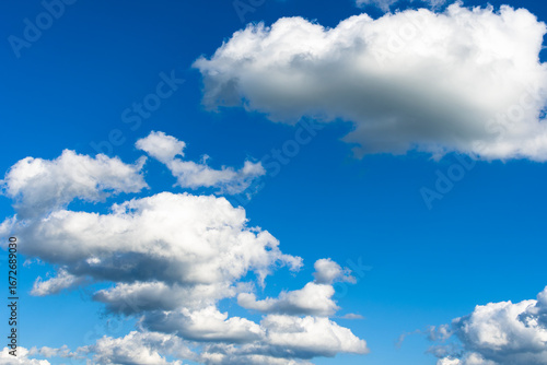 Scenic view of fluffy white clouds floating in clear blue sky