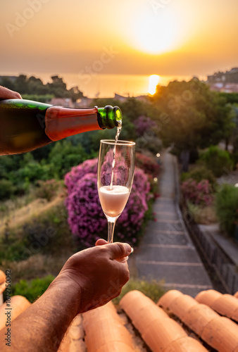 Summer vacation on Mediterranean sea, drinking cold rose champagne, cava sparkling wine in glass in sunlights, Collioure, Occitanie, South of France, tourists destination