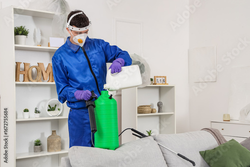 Male worker pouring disinfe...