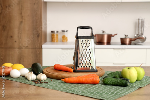 Grater with vegetables on t...
