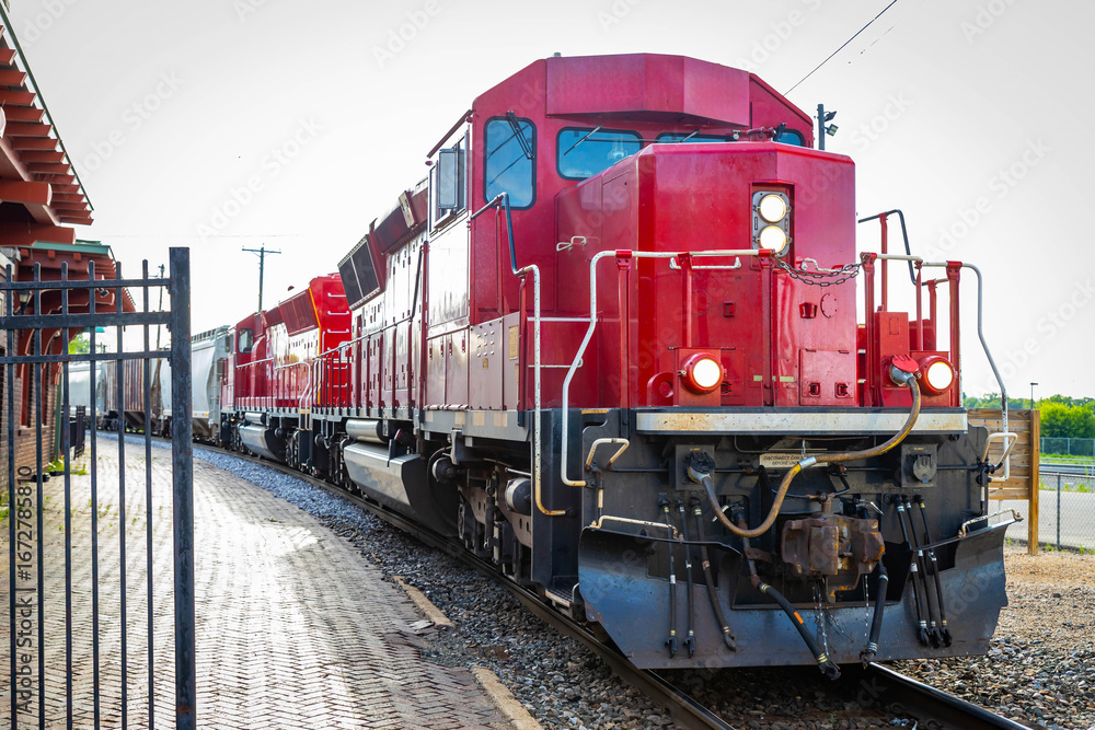 Naklejka premium Big Commercial Red Freight Train Close-Up at Station