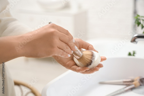 Wallpaper Mural Woman washing makeup brush with soap in bathroom, closeup Torontodigital.ca