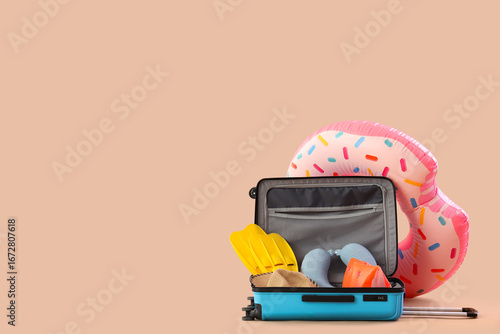 Schilderij op canvas Suitcase, inflatable ring and beach accessories on beige background