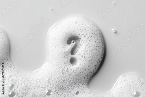 A question mark formed from white soap suds against a white background, with a soft, textured look