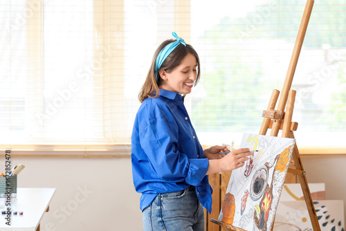 Young woman painting by num...