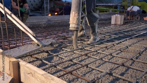 Concrete being poured onto rebar foundation at construction site