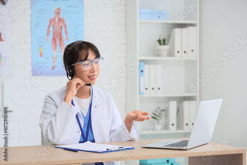 Female Asian doctor with la...