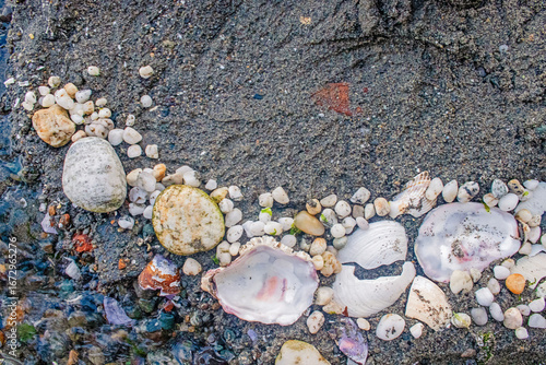Sand art with pebbles and seashells on a sandy Puget Sound beach