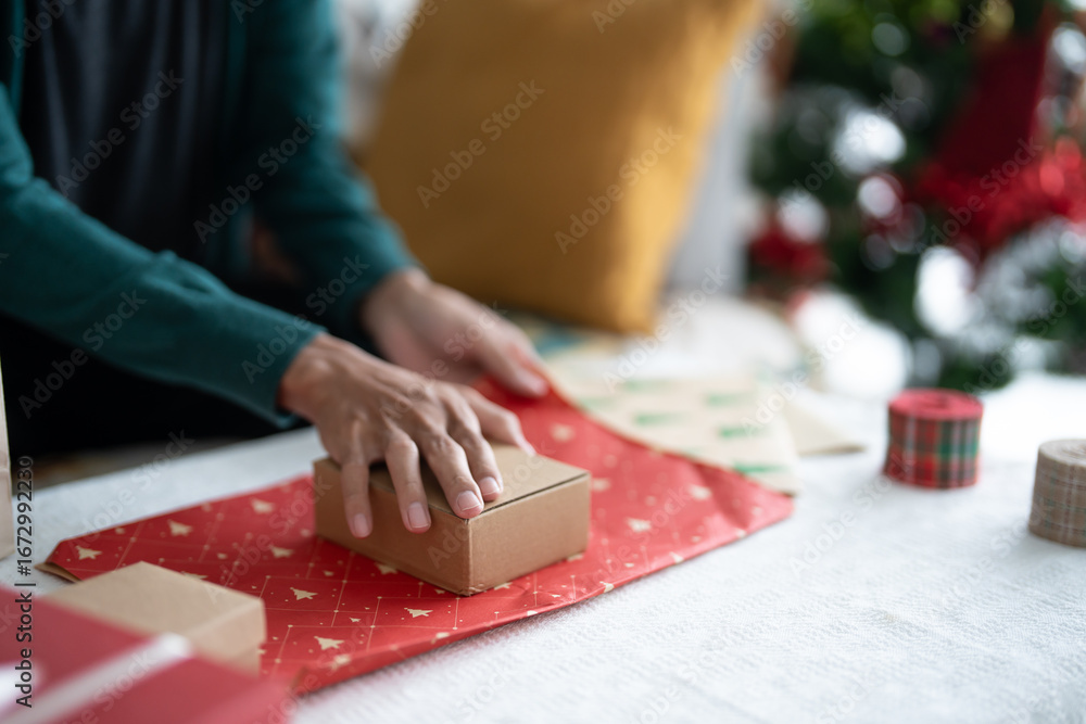 Obraz premium Man in sweater wrapping christmas presents with eco paper girl packing christmas gifts Xmas holiday concept