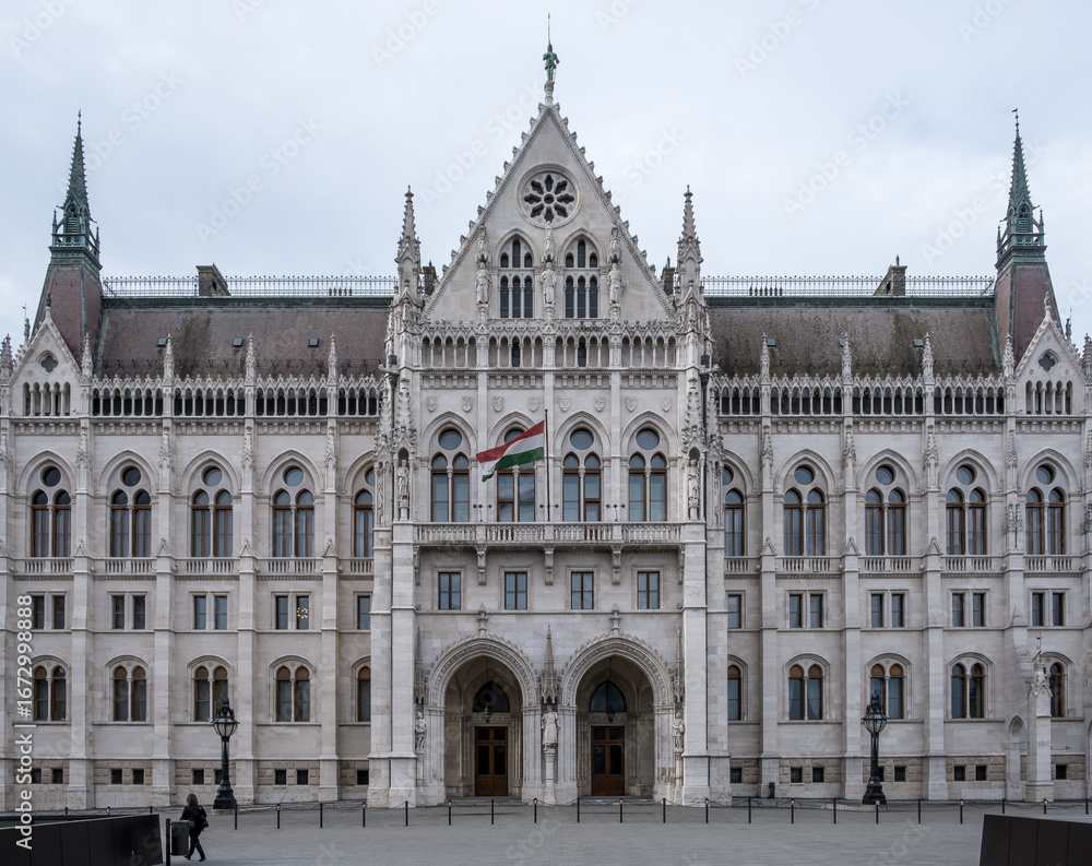 Fototapeta premium Budapest, Hungary – Architectural detail of the Hungarian Parliament Building (Országház), showcasing Neo-Gothic ornamentation, pointed arches, spires, and intricate stone carvings.
