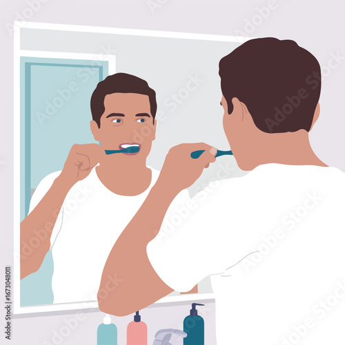 A man is brushing his teeth in the bathroom mirror, morning routine