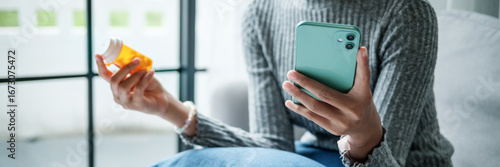 Female Asian holding drug bottle using smartphone for medical details