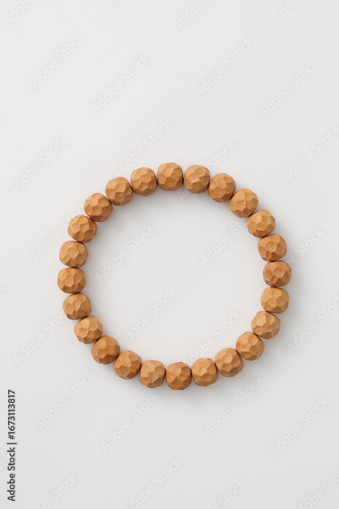 Obraz premium A wooden bead bracelet laid flat, showcasing natural materials and craftsmanship,Polygonal pattern engraving