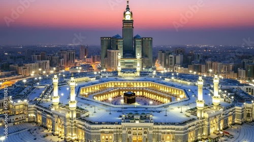 Majestic aerial view of Mecca's Grand Mosque during Hajj pilgrimage at dawn with Kaaba and modern city skyline in glowing light