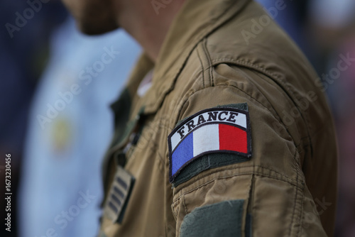 Shallow depth of field (selective focus) details with the French flag on the flight suit of a french pilot.