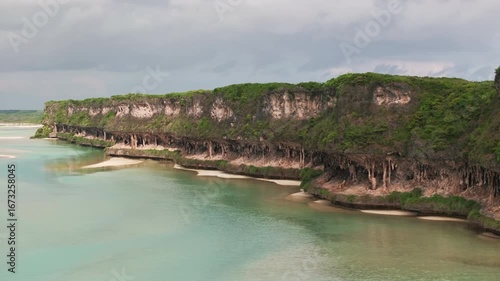 Wallpaper Mural Aerial view of Lekini Bay, Ouvéa, featuring turquoise waters, coral reef formations, limestone cliffs and lush tropical vegetation along the coastline. Torontodigital.ca