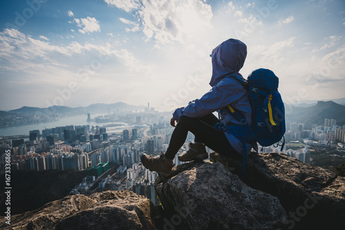 Photography Woman traveller sit on the cliff edge enjoy the beautiful view of hong kong