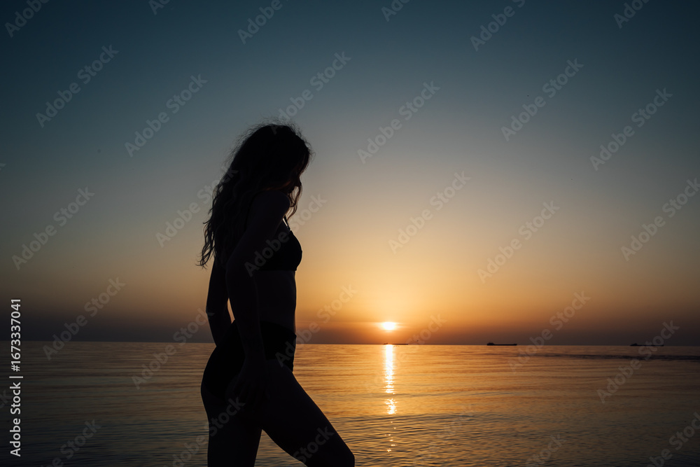 Fototapeta premium Sunset, sexy woman silhouette sea