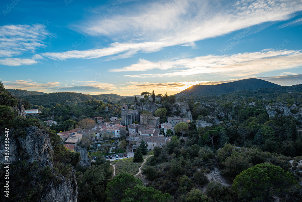 Fototapeta premium Village de Mourèze au crépuscule, Mourèze Village at Sunset, Vue aérienne du village de Mourèze, niché dans l’Hérault, au soleil couchant.