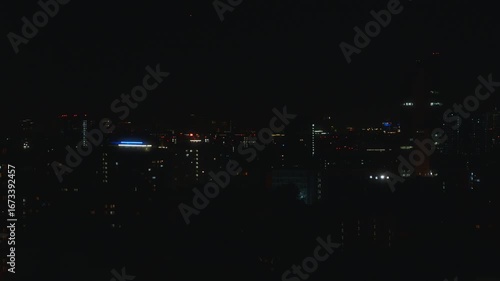 Wallpaper Mural Wide view of a city at night captured in deep darkness. Illuminated buildings and glowing windows create a scattered pattern of lights across the horizon. High quality 4k footage Torontodigital.ca