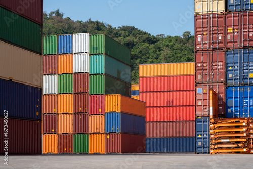 Colorful stacked shipping containers in a freight yard under clear sky, representing global logistics, cargo transport, and supply chain management.