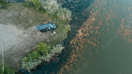 Overhead view of van life in Bavaria mini camper parked by a clear lake with mountains nature freedom and adventure