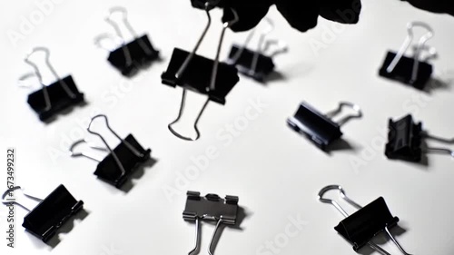 Binder Clips. Clips scattered desk. Picking binder clip. Metallic stationery detail. School Stationery. Study Tools. Classroom Essentials. Learning Supplies. Creative Desk. Writing Tools. 