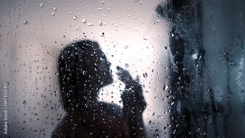 Fotografía Silhouette of a person in a shower looking thoughtfully through a raindrop-cover