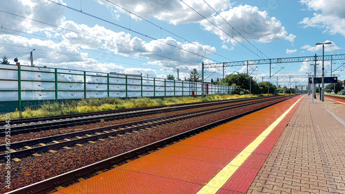 Village railway station platform with a shelter and seats on a sunny summer day with the rail track in perspective disappearing to a vanishing point on the horizon, Nottinghamshire, England, UK
