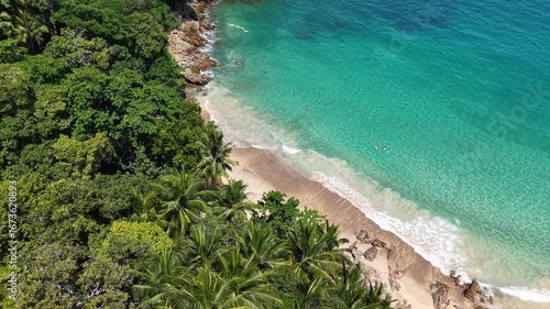 A mesmerizing aerial panorama of a secluded tropical beach, where the turquoise ocean meets the golden sand, creating an idyllic landscape that embodies serenity and natural beauty.