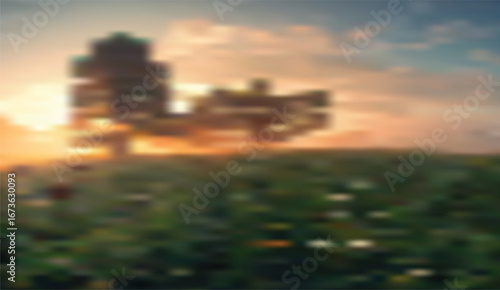 Scenic golden hour bathes a field of green, highlighting silhouetted structures against a softly blurred sky with hues of orange and blue that create a tranquil atmosphere
