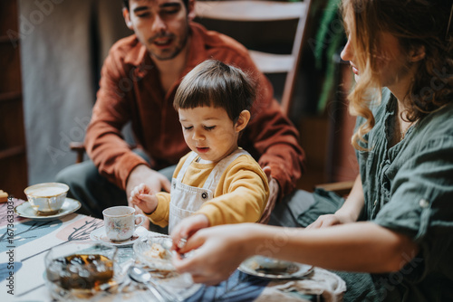 Photos Family bonding moment as parents and their child enjoy a cozy meal at home