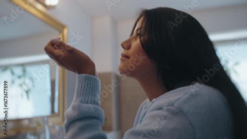 Latina Woman Applying Perfume in Bathroom Mirror Before Going Out