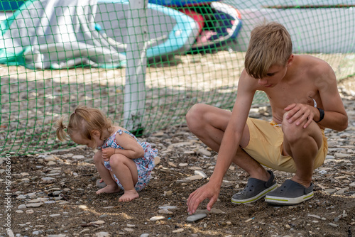 Foto Sibling bond: young boy and his little sister engaging in quiet moment, crouchin
