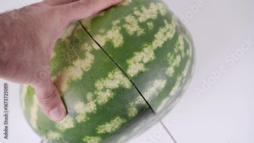 Cutting a watermelon with precision in a clean kitchen environment to showcase effective techniques for summer enjoyment