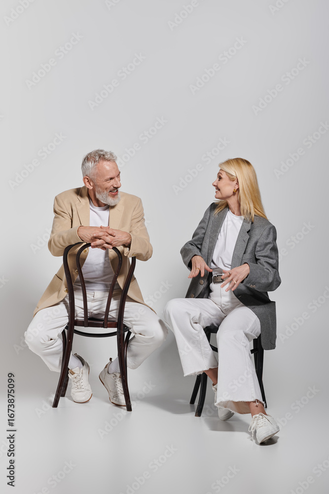 Fototapeta premium Stylish senior couple enjoying a joyful moment together while seated in a chic setting