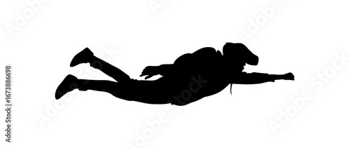 A dramatic silhouette of a person free diving or scuba diving, lying horizontally in the water.