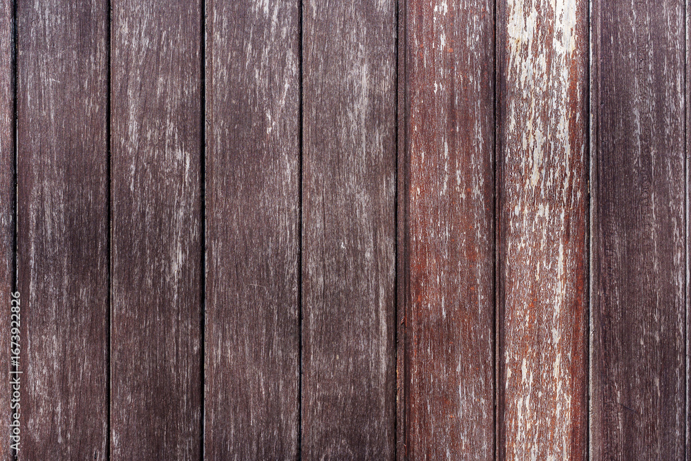 Naklejka premium A rustic background of vertical, weathered brown wood planks. An aged, textured wooden surface with a distressed, vintage feel.