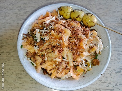 Indonesian chicken porridge or locally named Bubur Ayam.  Usually served with quail eggs, crackers, shredded chicken, chili sauce, and soy sauce. Chicken porridge is one of Indonesia's favorite foods.