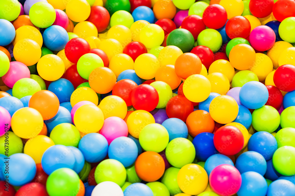 Obraz premium A sea of colorful plastic balls fills a childrens play area inviting kids to jump in and enjoy the vibrant atmosphere Sunlight enhances the playful setting creating joy