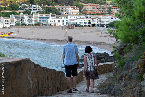 Pareja caminando por el Camino de Ronda hacia la playa de Sa Riera en Begur, Costa Brava