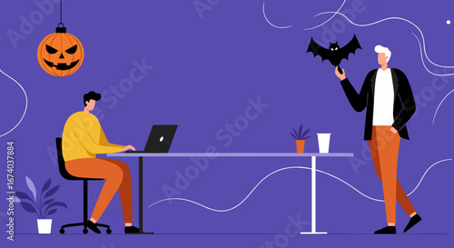 Office colleagues celebrate Halloween. One works on a laptop while the other holds a bat decoration, blending holiday spirit with a modern workspace.