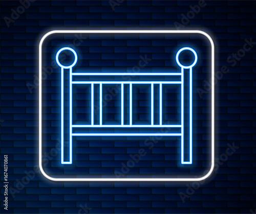 Glowing neon line Baby crib cradle bed icon isolated on brick wall background. Vector